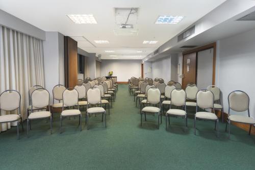 a room with a row of chairs in a room at Golden Tulip Porto Vitória in Vitória