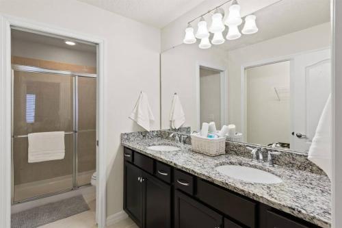 baño con 2 lavabos y espejo grande en Luxury 5BD/5BH Home With Pool/BBQ Disney Universal en Kissimmee