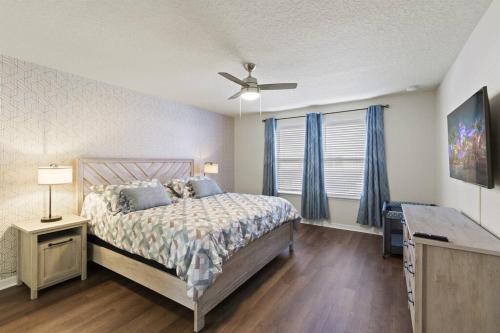 a bedroom with a bed and a ceiling fan at Luxury 5BD/5BH Home With Pool/BBQ Disney Universal in Kissimmee