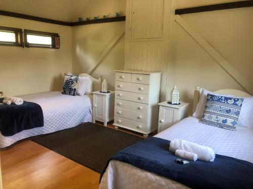 a bedroom with two beds and a dresser at Sycamores Barn - Detached, Private, Secluded Country Retreat in Brighstone
