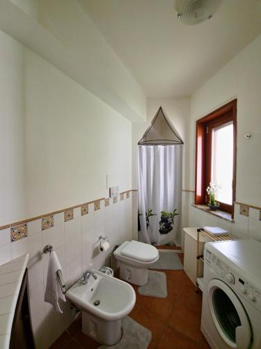 a bathroom with a toilet sink and a washing machine at Tok Tok Taormina in Taormina