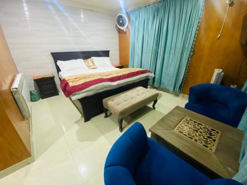 a bedroom with a bed and a blue chair at Shagufta Hotel Murree in Murree