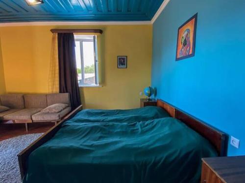 1 dormitorio con 1 cama grande y 1 sofá en Noosh guesthouse en Ashnak
