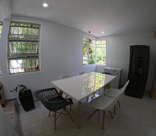 une salle à manger avec une table et des chaises blanches dans l'établissement HABITACION DE LUJO CON BAÑO PRiVADO, à Valledupar