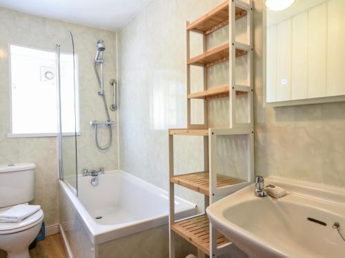 a bathroom with a tub and a toilet and a sink at 21 Mill Green in Lyme Regis