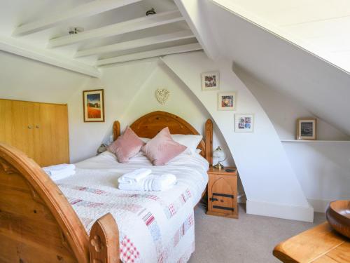 a bedroom with a bed with pink pillows at 21 Mill Green in Lyme Regis