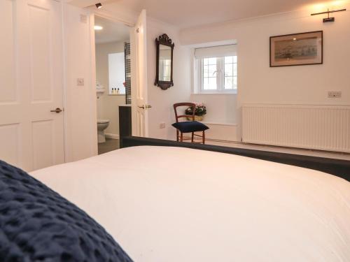 a bedroom with a bed and a chair in a room at Shipwrights in Brixham