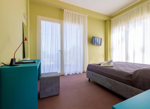 1 dormitorio con 1 cama, vestidor azul y ventanas en Fani Rooms, en Salve