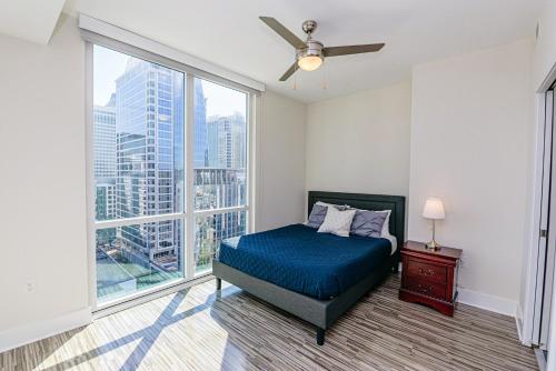 um quarto com uma cama e uma grande janela em Corporate Uptown Furnished Apartments em Charlotte