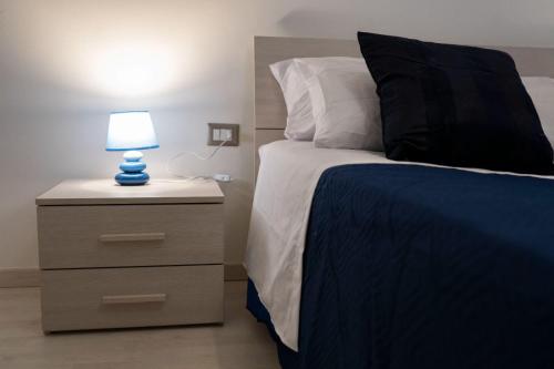 a bedroom with a bed with a blue lamp on a nightstand at B&BSCICCHERI in Castellammare di Stabia
