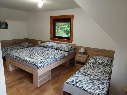 a bedroom with two beds and a window at Chata u Michala- neakceptujeme mladé partie in Terchová