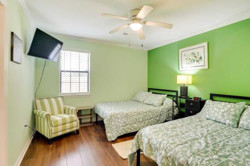 1 dormitorio con 2 camas, silla y ventilador de techo en Vibrant North Charleston Duplex Near Airport!, en Charleston