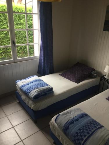 deux lits jumeaux dans une chambre avec fenêtre dans l'établissement La croix fleurie des landes, à Saint-Pierre-dʼOléron