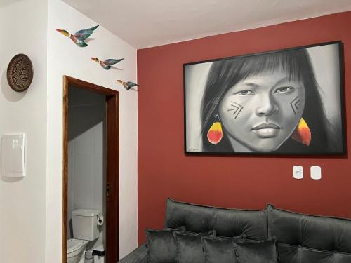 un soggiorno con un dipinto di una donna su un muro di Lindo Apê em Coroa Vermelha BA a Santa Cruz Cabrália