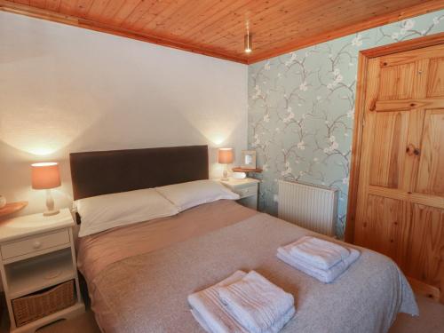 a bedroom with a bed with two towels on it at Little Gem in Maryport