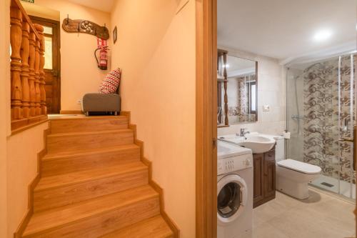 a bathroom with a staircase and a sink and a washing machine at Belmonte, apartamento en Ribadesella in Ribadesella