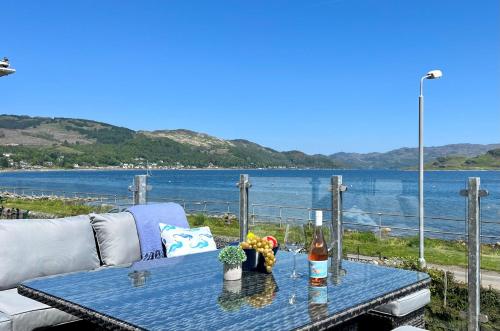 una mesa azul con sofá y vistas al agua en Craignethan, en Kames