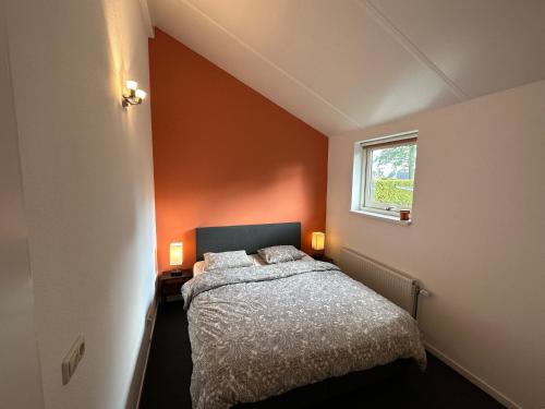 Habitación pequeña con cama y ventana en Modern Vacation home - Near the Wadden Sea en Tzummarum