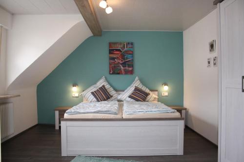 um quarto com uma cama com uma parede azul em Ferienwohnung zur Trübenbach em Kirn