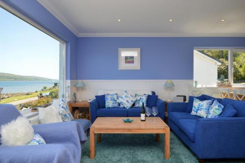 a blue living room with two blue couches and a table at Craignethan in Kames