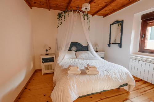 a bedroom with a white bed with towels on it at Casa Rural La Lar in Otero de Bodas