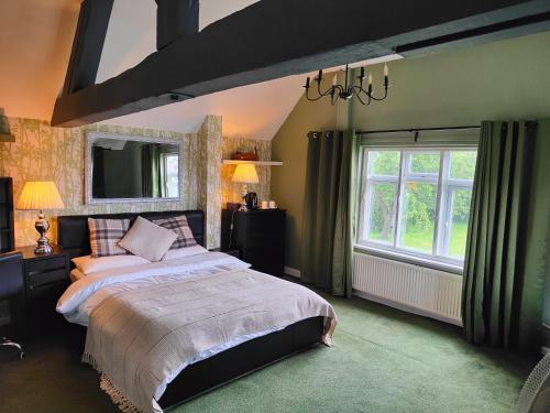 um quarto com uma cama grande e uma janela grande em Mackworth House Farm em Derby