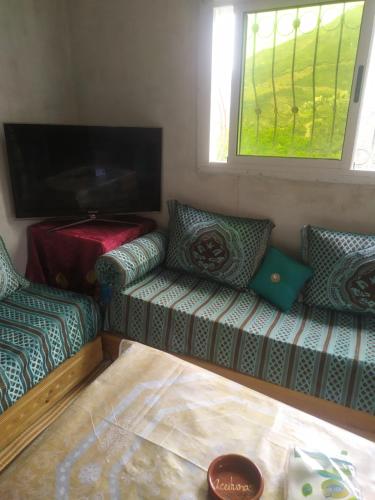 a living room with a couch and a tv at Ferme de cannabis à ketama in Tlata Ketama