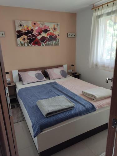 a bedroom with a bed with two towels on it at Apartmani SLADJANA in Novi Sad