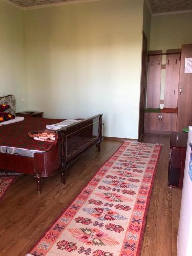 a room with a bed and a rug on the floor at AltynAi Guest House in Cholpon-Ata