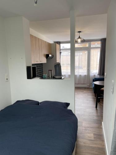 Cet appartement comprend une chambre avec un lit noir et une cuisine. dans l'établissement Merlimont-plage: studio, à Merlimont