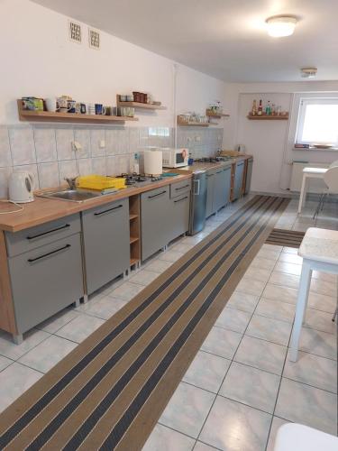 a large kitchen with stainless steel appliances in a room at Klocek in Mrzeżyno