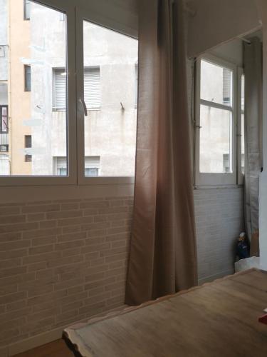a bedroom with a window and a bed with a curtain at ARIN alojamientos in Lleida