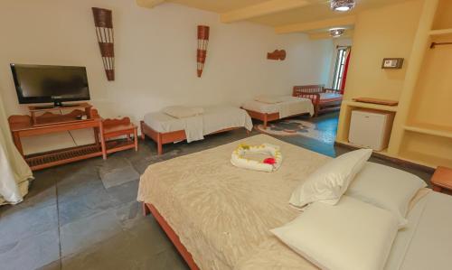 a living room with a couch and a tv at Estação Santa Fé Hotel e Pousada in Arraial d'Ajuda
