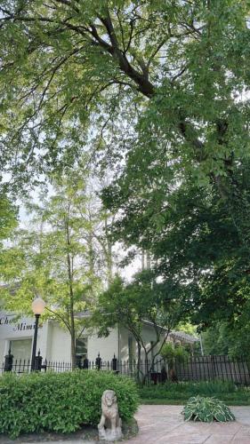 a statue in front of a white building with a fence at The Ginkgo Tree in Mount Pleasant