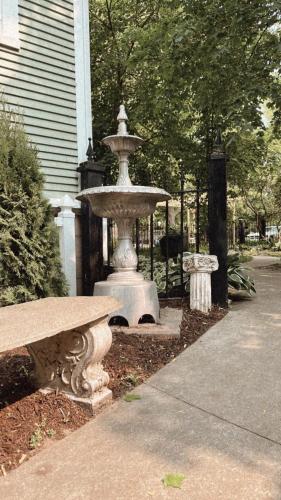 a fountain in front of a house with a bench at The Ginkgo Tree in Mount Pleasant