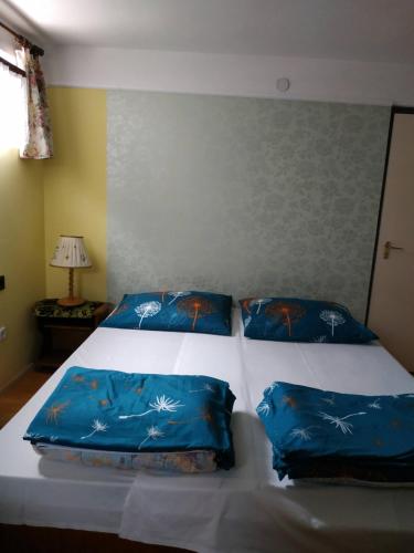 鮑洛通哲勒克的住宿－Tóth nyaraló，卧室配有2个蓝色枕头
