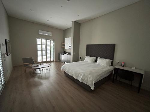 1 dormitorio con 1 cama, mesa y sillas en The Wantage Suites, en Johannesburgo