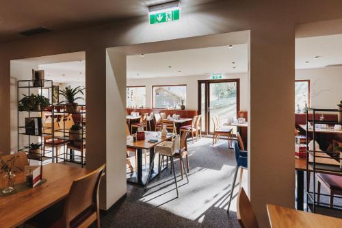 a restaurant with tables and chairs and a sign on the wall at Familienhotel Lagant in Brand