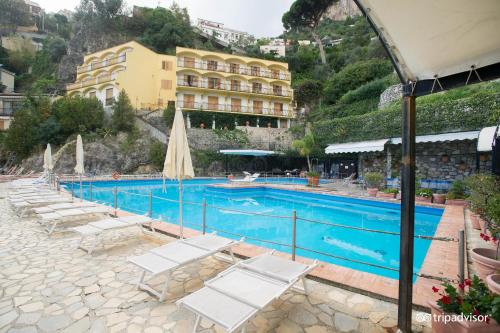 una piscina con sedie a sdraio e un hotel di Luxury Suite Royal Positano a Positano