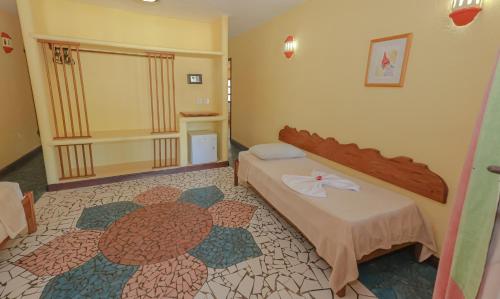 a hotel room with a bed and a carpet at Estação Santa Fé Hotel e Pousada in Arraial d'Ajuda