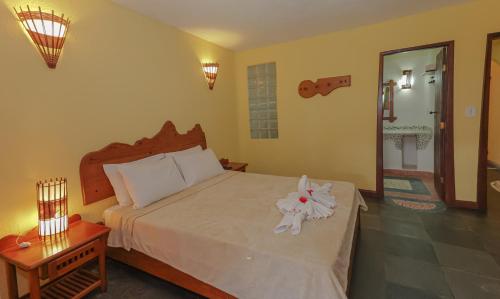 a bedroom with a bed with a stuffed animal on it at Estação Santa Fé Hotel e Pousada in Arraial d'Ajuda