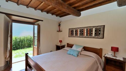 a bedroom with a bed and a large window at Podere Le Coste in Loro Ciuffenna