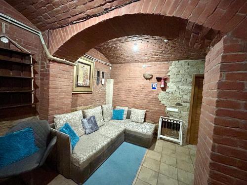 a living room with a couch and a brick wall at Budget Family Hotel in Lviv