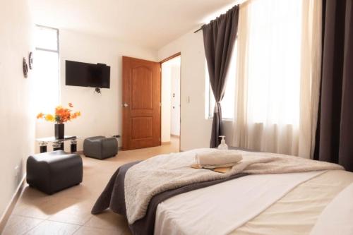 1 dormitorio con 1 cama grande y TV en Hostal Encanto PAISA en Medellín