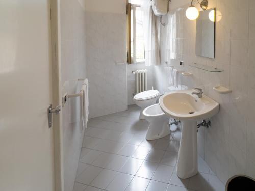 ein weißes Bad mit einem Waschbecken und einem WC in der Unterkunft Monte Marsicano Hotel in Pescasseroli