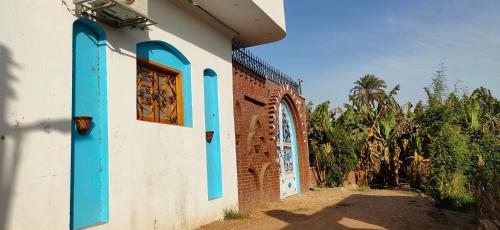 a building with blue windows and a brick wall at Ra house in Luxor