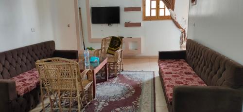 a living room with couches and a table and chairs at Ra house in Luxor