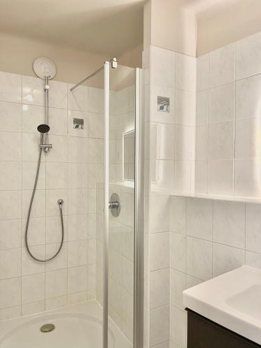 a shower with a glass door in a bathroom at Homely Stay Apartment 3 in Sankt Pölten