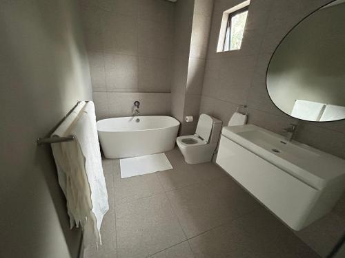 y baño con bañera, aseo y lavamanos. en The Wantage Suites, en Johannesburgo