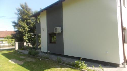 a white building with a window on the side of it at Kuća za odmor V&E in Bihać